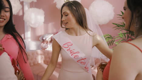 close up view of happy bachelor girl wearing a bride to be sash with her friends