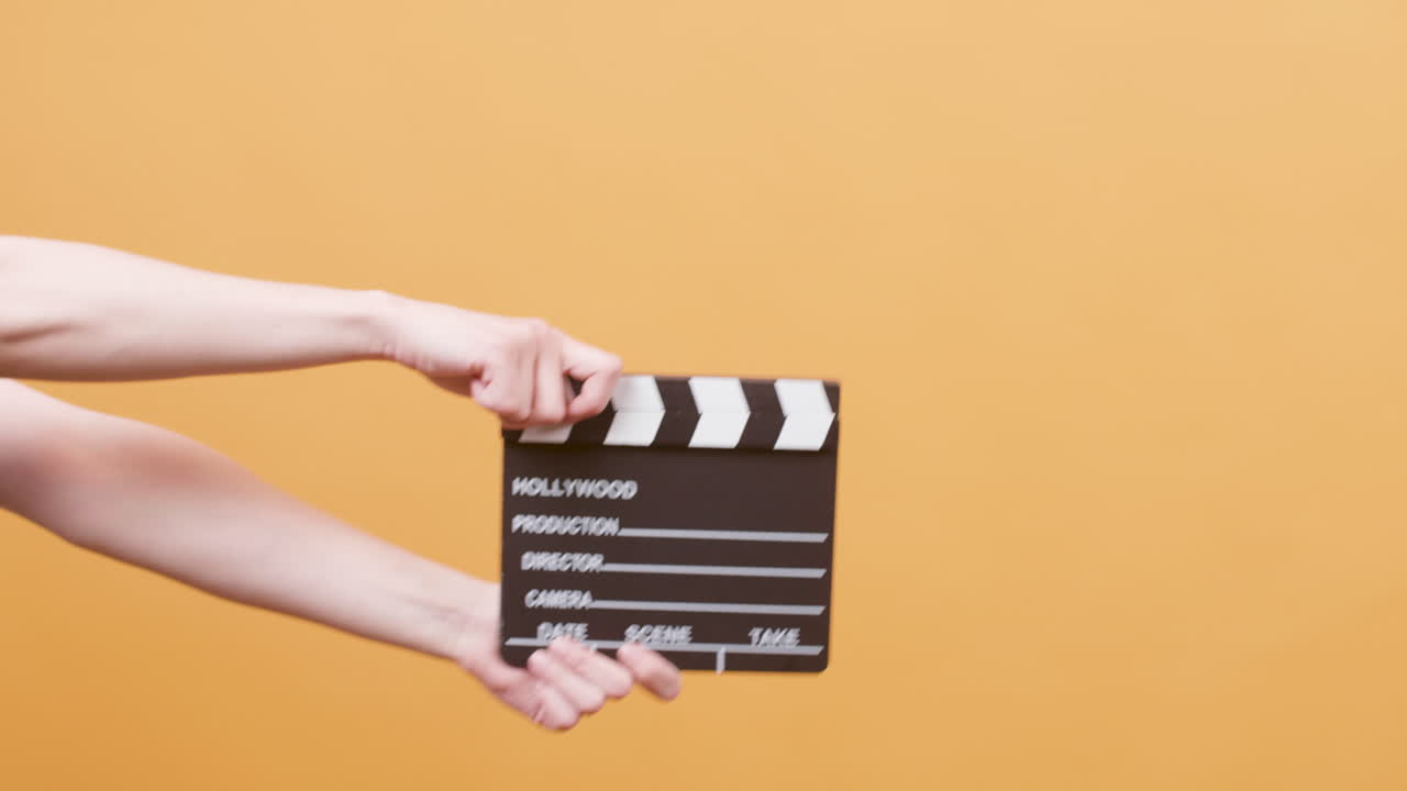 Hands holding a clapperboard