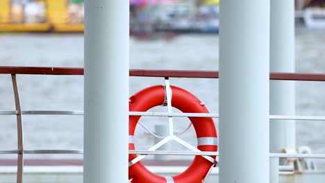 red life buoy hanging on boat railing in bangkok river