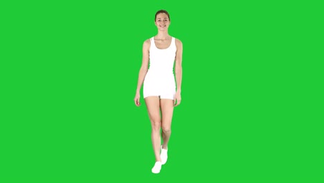 sporty styles woman walking in white on a green screen, chroma key