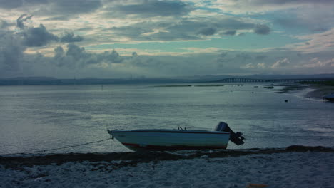 portuguese-sea,-a-boat-on-the-sand-during-the-sunset-in-Lisbon