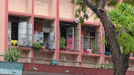 open windows of old apartment building in kota kinabalu, malaysia. - wide shot