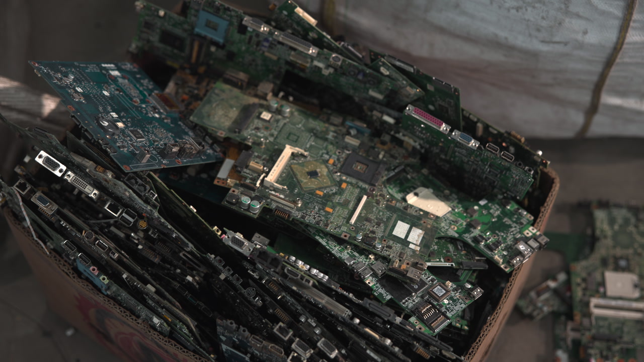 Stacked Circuit Boards In Scrap Box, Green PCBs And Gold Traces Visible, Broken Connectors And Capacitors, . Media