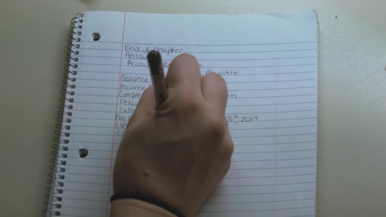 A close-up of a caucasian hand writing down notes during an economy class.