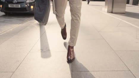 Close-crop-of-businessman-feet-walking-in-city