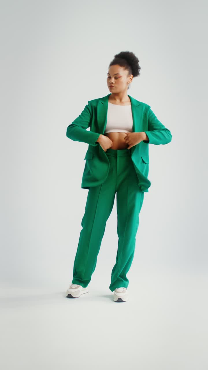 Woman in green suit and white crop top