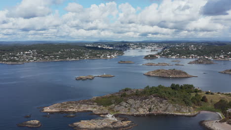 aerial high pan of seaside arendal cityscape with white clouds, norway