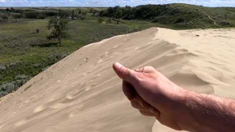 a hand full of sand blowing away in the wind