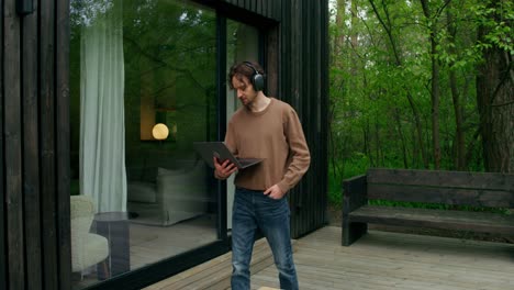 man working on laptop outdoors on a porch