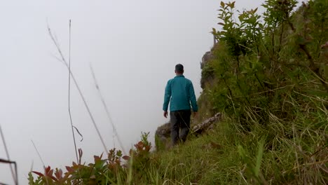 Mann-Macht-Yoga-Am-Bergfelsen-Mit-Weißem-Nebelhintergrund-Aus-Flachem-Winkel