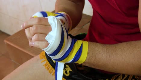 Athlete-Putting-Boxing-Wraps-on-his-Hands-while-Sitting-in-the-Change-Room