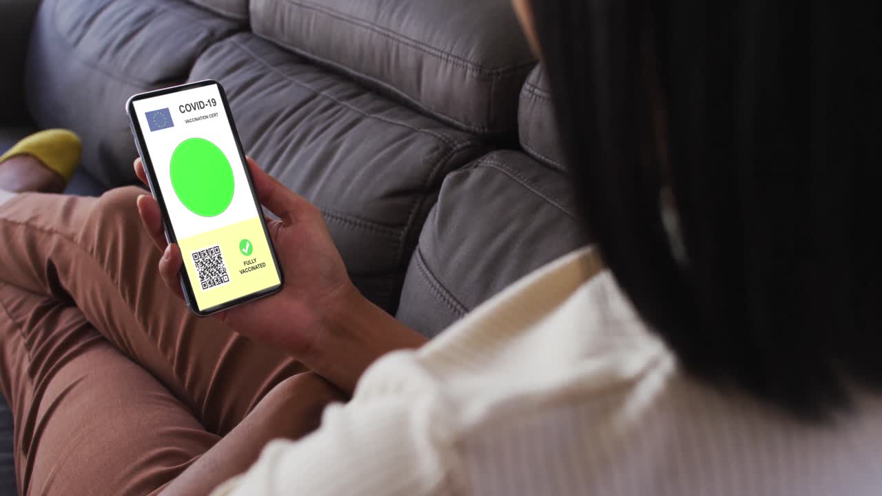 mujer en casa con un teléfono inteligente con certificado de vacunación contra la covid, bandera de la ue y código qr en la pantalla