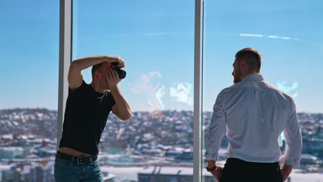 young man working with camera in office. businessman posing on camera. professional photographer taking photos of a male model. photo session near window.