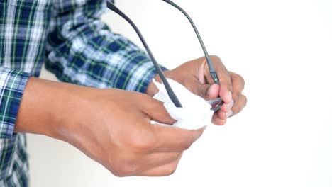 man cleaning his glasses with a cloth