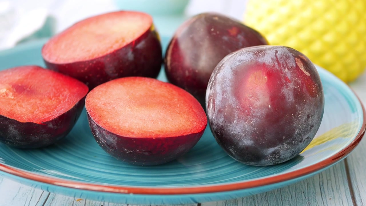 Fresh Red Plums on a Blue Plate