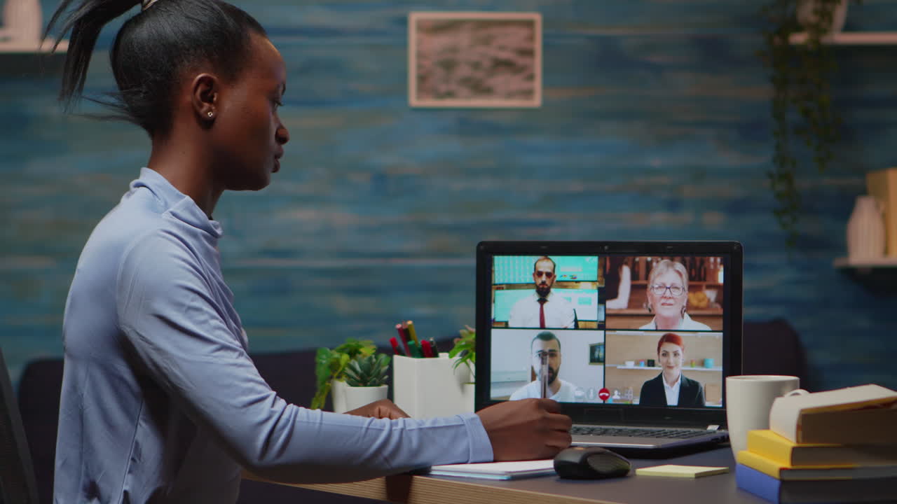 Black freelancer working remotely speaking with coworkers online