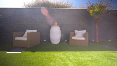 Slow-establishing-shot-of-furniture-sitting-in-the-shade-beside-a-small-palm-tree