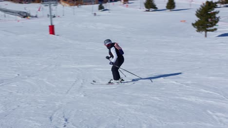 woman skiing down a snowy slope in slow motion on a sunny day