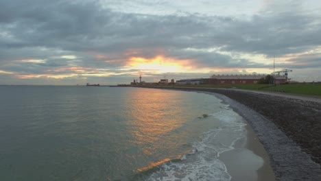 Aerial:-The-boulevard,-beach-and-city-of-Vlissingen-during-sunset