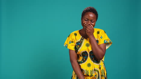 Cute-female-model-giggling-against-blue-background-in-studio