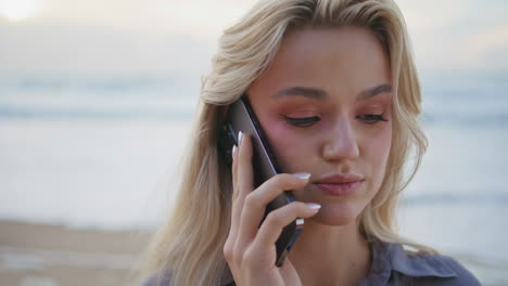 relaxed tourist speaking smartphone at ocean sunset. closeup pretty girl calling