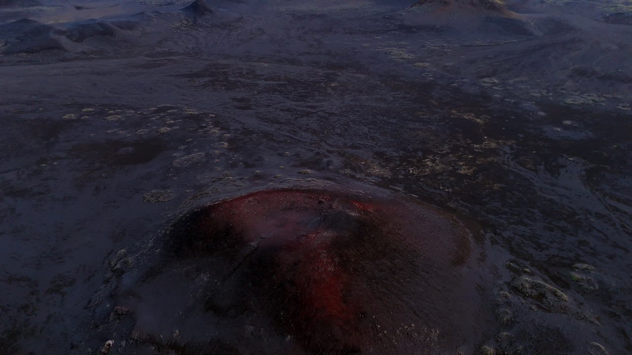 Cinematic aerial drone view of volcanic craters and lava fields in Iceland highlands, barren volcanic desert, rugged mountains and dramatic Nordic landscape, nature and geology background