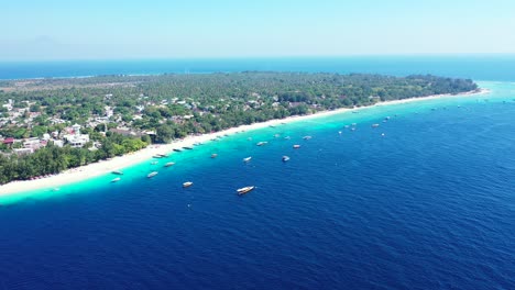 Colorful-seascape-with-white-sandy-beach-of-tropical-island,-washed-by-blue-azure-sea-where-boats-floating-in-Indonesia