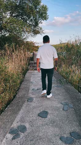 man walking along a lakeside path