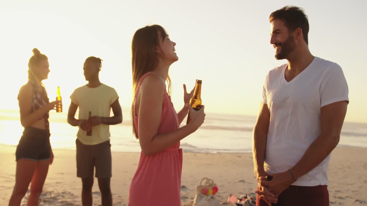 해가 지는 해변에서 술을 마시는 젊은 성인 친구들 4k