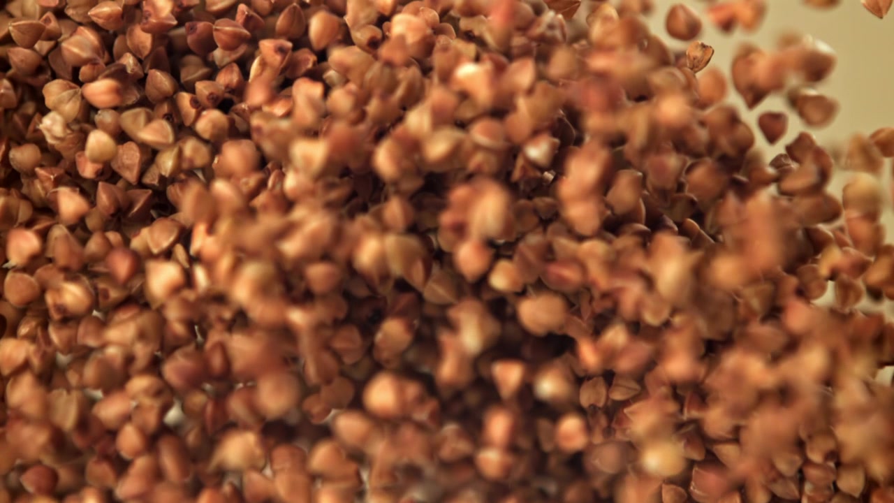 Grano saraceno che cade e si accumula al rallentatore