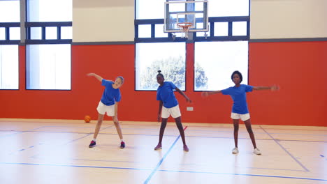 in school gym, kids stretching and exercising during physical education class together