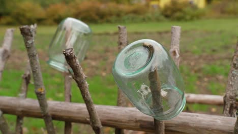 glass jars are drying on the fence of the hayloft