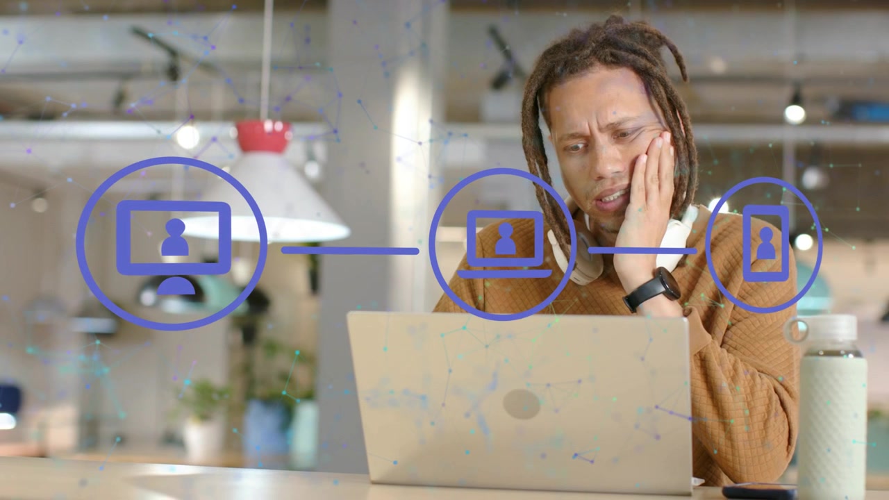 IT worker working on laptop, screen appearing and connecting to laptop and phone, he testing audio