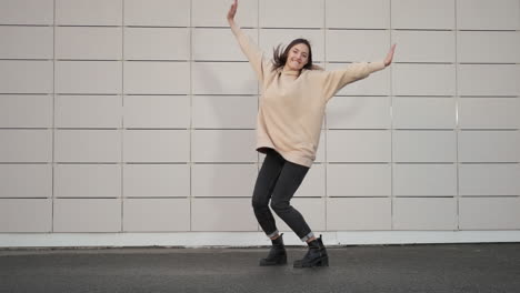 stylish woman posing in a beige hoodie and black boots