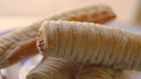 slow motion close up of sausage rolls on plate after baking. delicious traditional english fresh bakery product. british snack cuisine. pork meat wrapped in puff pastry.
