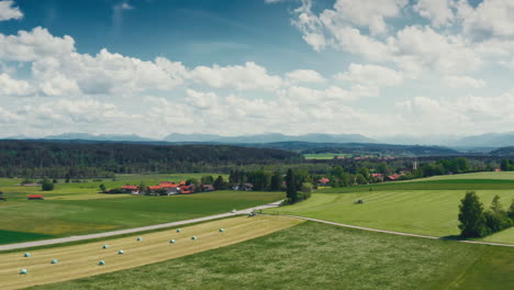 the idyllic countryside of western germany through aerial footage capturing serene villages, mowing tractors, and harvested fields under clear blue skies