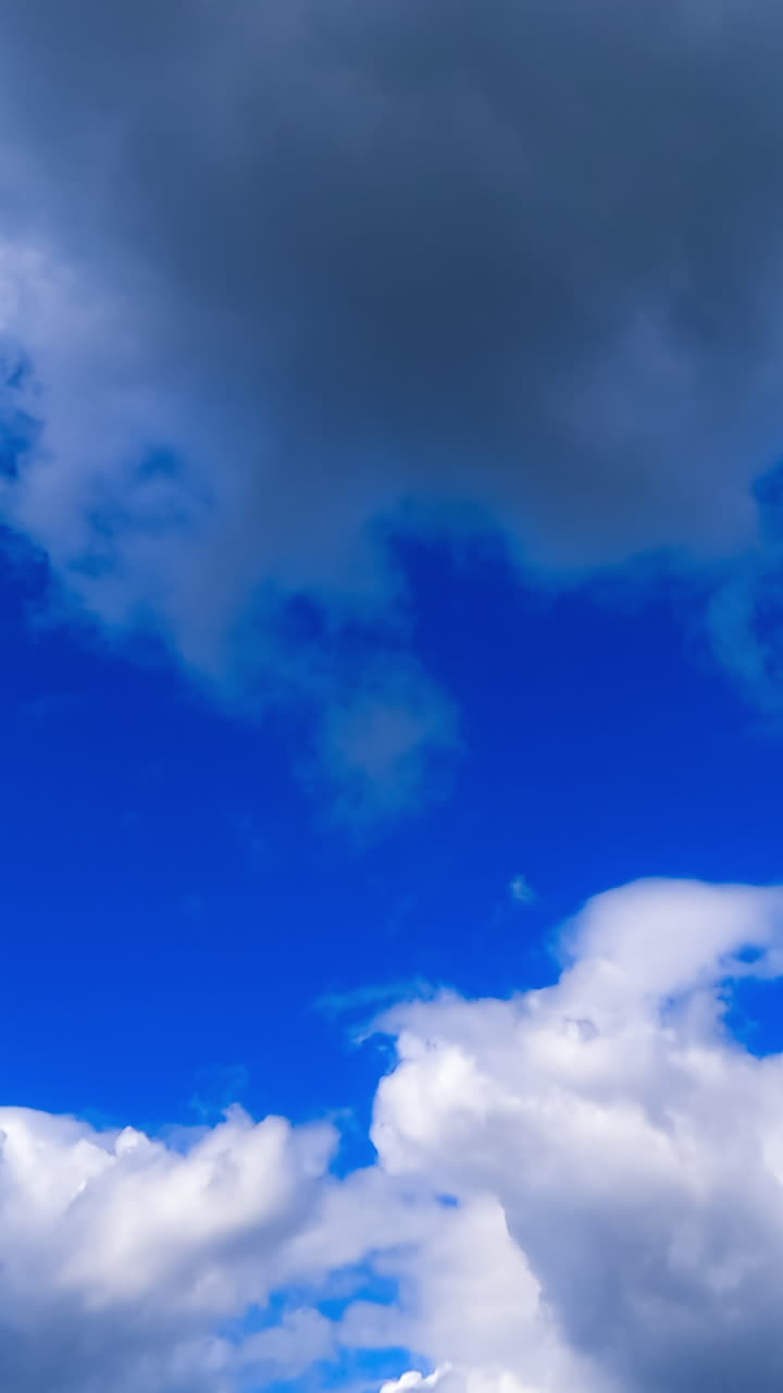 Timelapse of fluffy clouds motion. Blue sky with clouds flowing over. Vertical video