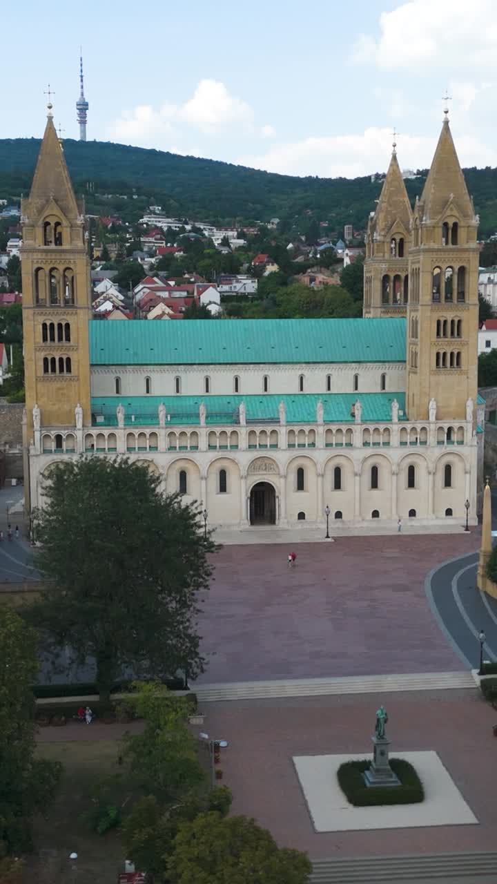 Pécs Cathedral facade, emphasizing ornate architecture and roof details. Vertical Drone Shot