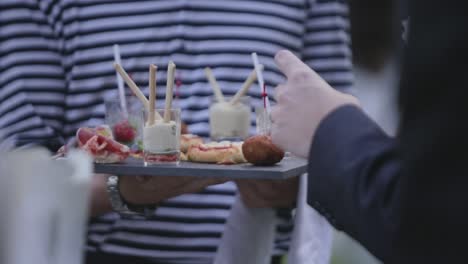 el invitado de la boda tomando canape de cono del camarero