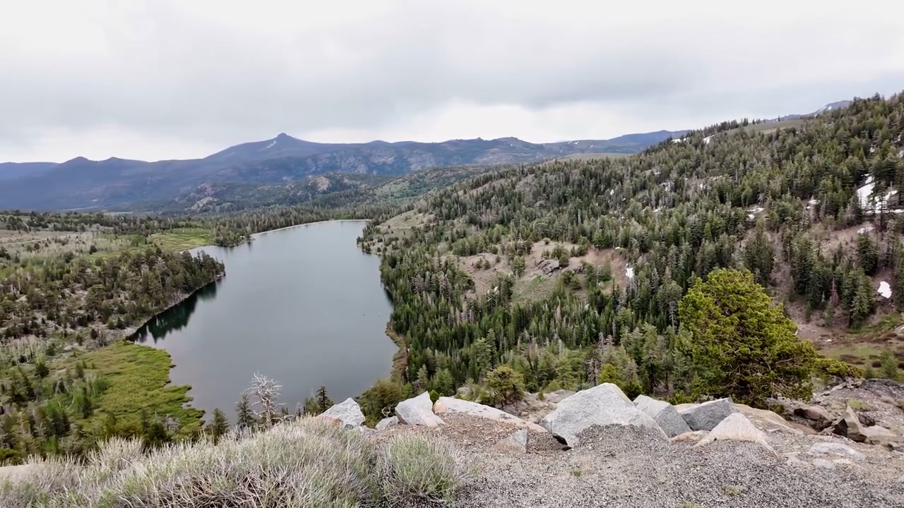 Una panoramica che rivela il lago incontaminato circondato da foreste di pini e montagne innevate al Carson Pass, un bellissimo punto di riferimento naturale nella Sierra Nevada
