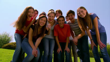 a group of happy teenagers smiling outdoors