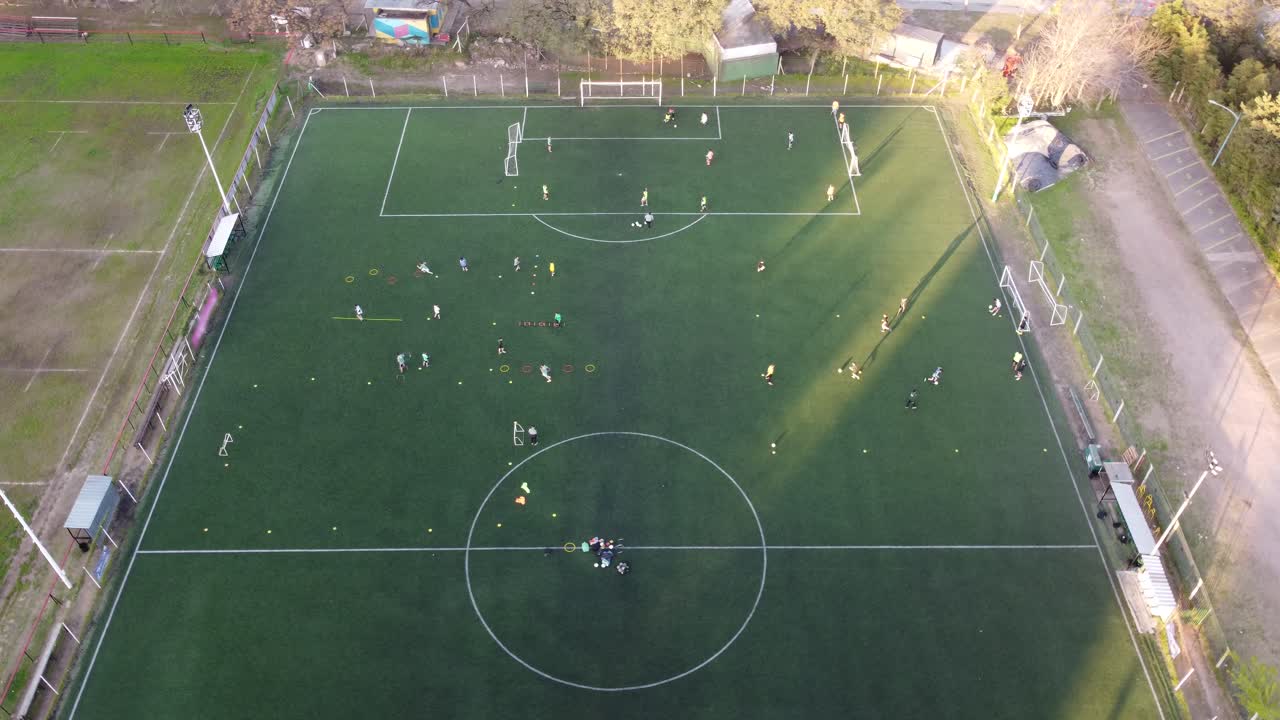 top down aerial view of a football training session in the Buenos Aires club at sunset