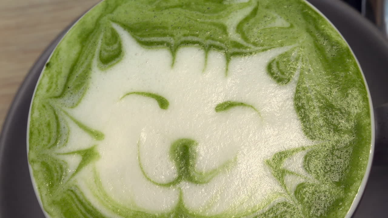 Close up of a kitten latte art on a matcha latte