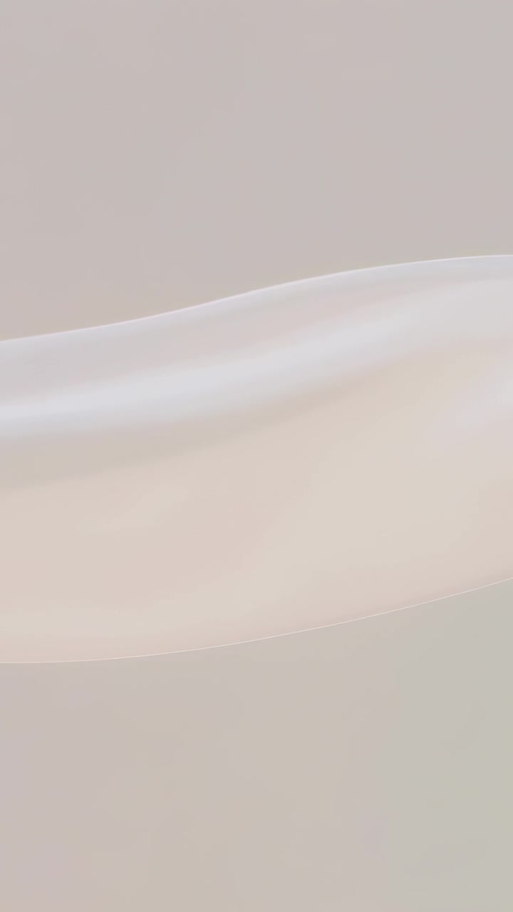 Vertical video: Entering left, silk ribbon waving and settling on soft gray wall for abstract loop