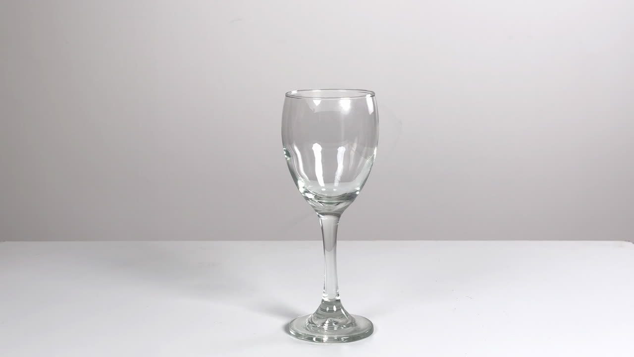Mano posa e fa tintinnare calici da vino vuoti