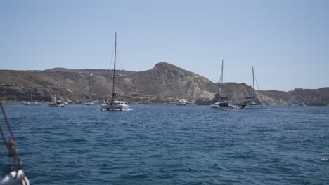 slow motion shot of a catamaran exploring the santorini coastline during summer