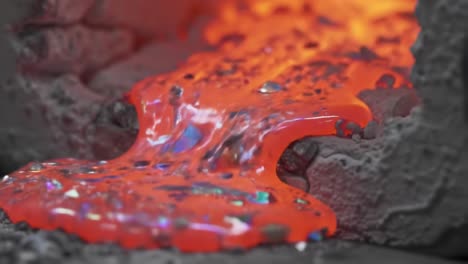 mesmerizing flow of molten metal: a close-up exploration of lava-like liquid transitioning from hot to vibrant red in a foundry setting