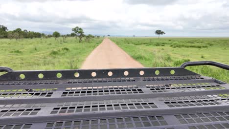 view from safari jeep rooftop leaving dirt trail in mikumi national park reserve in tanzania