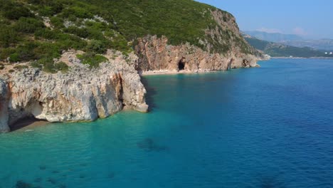toma de drone de la costa albanesa en el mar mediterráneo - drone está dando vueltas alrededor del acantilado, revelando una playa