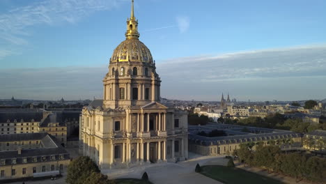 Un-Disparo-De-Drone-Se-Eleva-Para-Revelar-Un-Sol-Poniente-Que-Brilla-En-La-Iglesia-De-La-Cúpula-En-París,-Francia